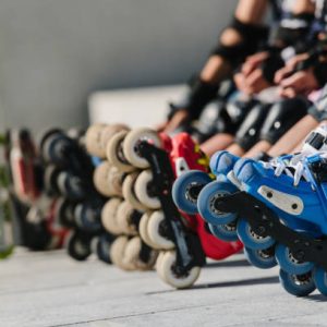 Feet of rollerbladers wearing inline roller skates sitting in outdoor skate park, Close up view of wheels befor city race for healthy and active life